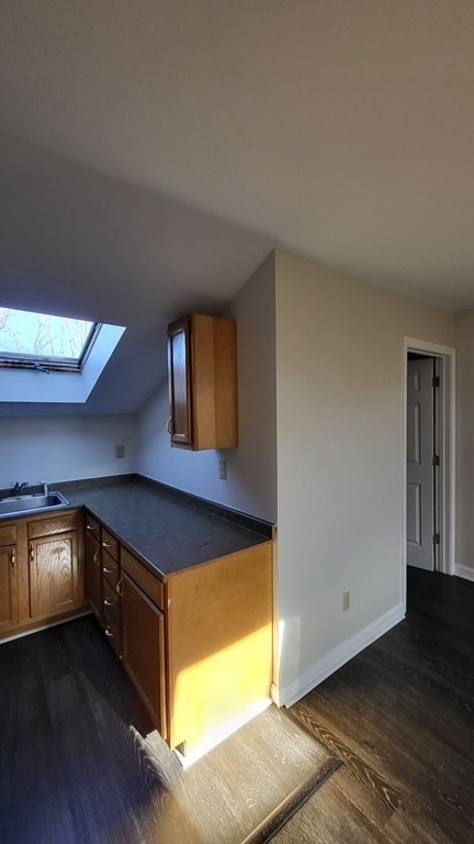 124 Stevens Street, Unit 5 Lowell, MA 01851 - Photo 7 of 15 a view of an empty room with wooden floor and a window