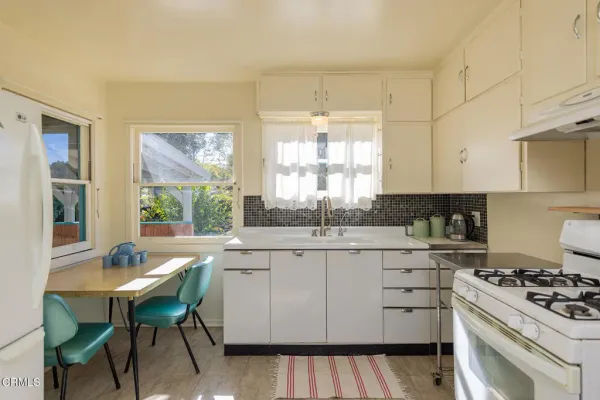 a kitchen with a stove a sink and cabinets