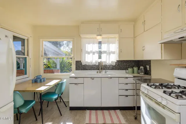 a kitchen with a stove a sink and cabinets