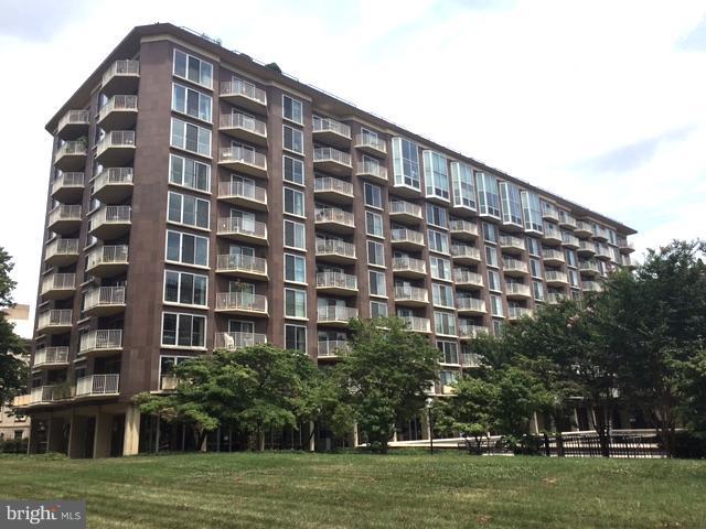 a view of a tall building sitting in the middle of a yard