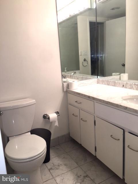 560 N Street Southwest, Unit N107 Washington, DC 20024 - Photo 7 of 10 a bathroom with a granite countertop toilet sink and mirror