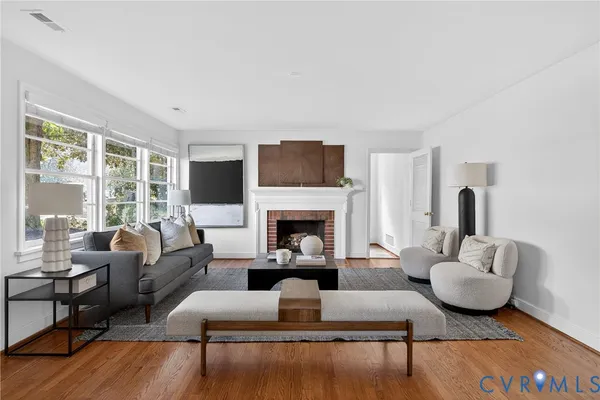 a living room with furniture fireplace and a large window