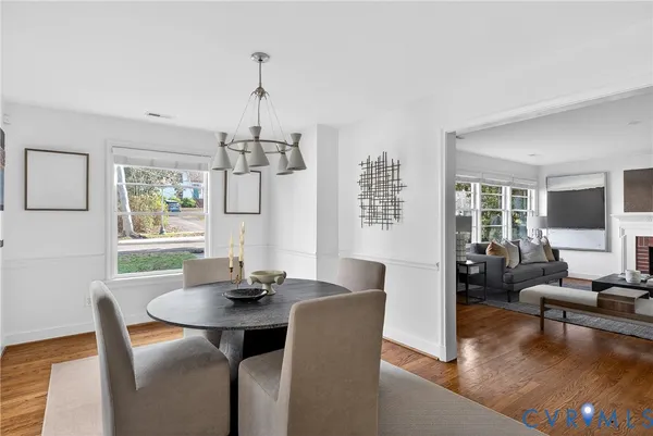 a dining room with furniture a chandelier and wooden floor