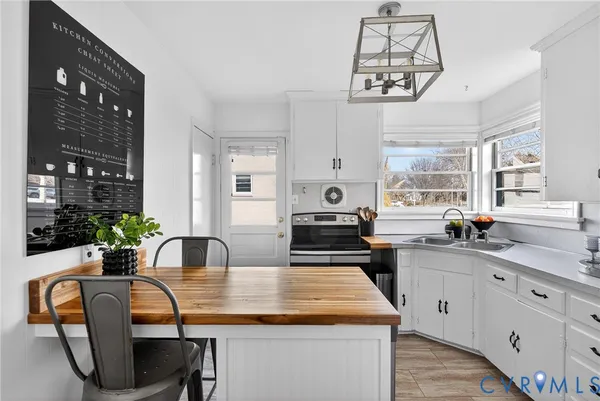 a kitchen with granite countertop a sink chairs and cabinets