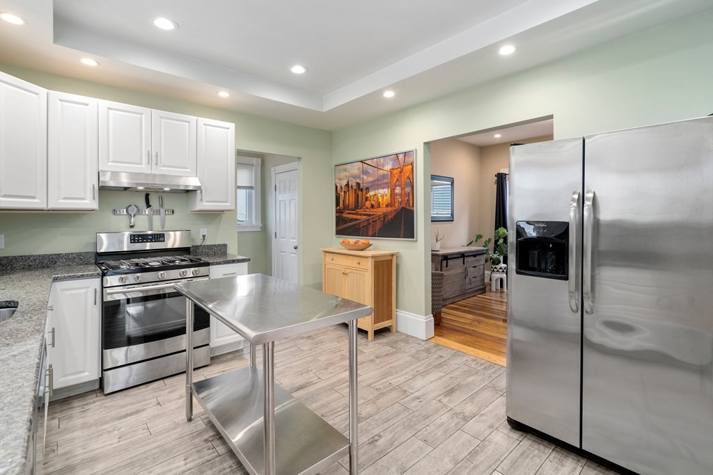 9 Baker Road Everett, MA 02149 - Photo 6 of 14 a kitchen with granite countertop a stove a sink and a refrigerator
