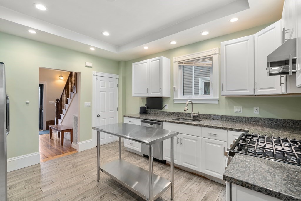 9 Baker Road Everett, MA 02149 - Photo 7 of 14 a kitchen with stainless steel appliances granite countertop a stove a sink a refrigerator and white cabinets
