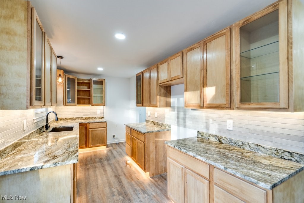 3720 Baird Road Stow, OH 44224 - Photo 8 of 45 Kitchen with light stone countertops, sink, pendant lighting, and light hardwood / wood-style flooring