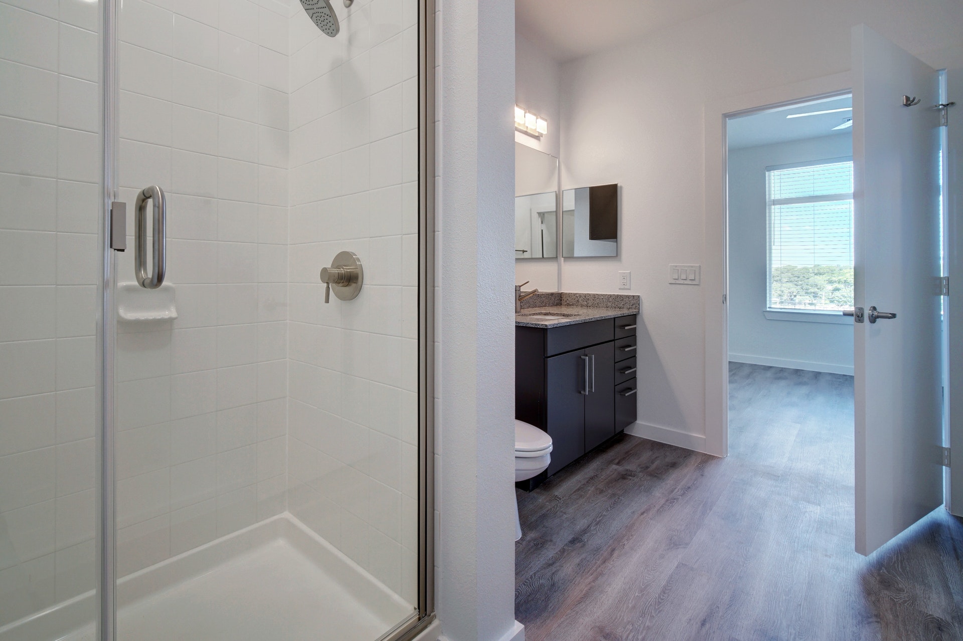 13130 Pond Springs Road, Unit 3214 Austin, TX 78729 - Photo 19 of 40 Bathroom with vanity, a stall shower, and dark wood-type flooring