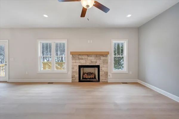 an empty room with windows and fireplace