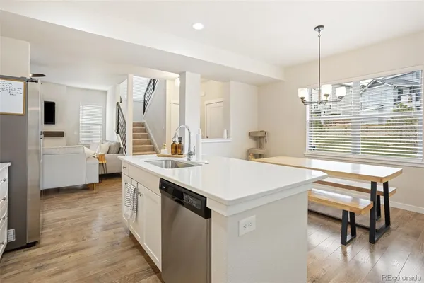 a view of kitchen island a sink wooden floor and a window