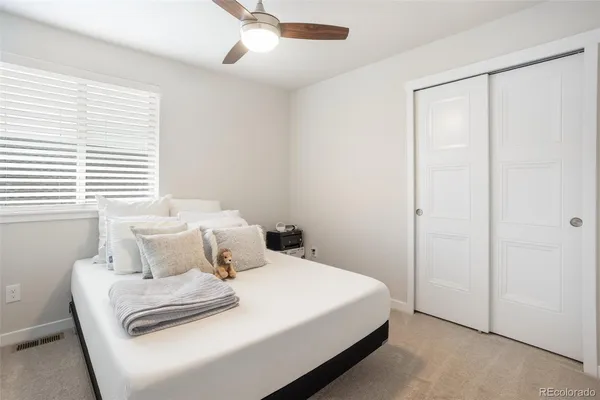 a bedroom with a white bed and window