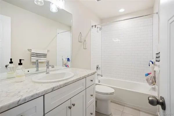 a bathroom with a granite countertop sink a toilet and shower