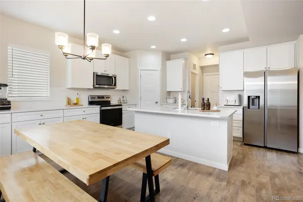 a kitchen with kitchen island a sink counter space stainless steel appliances and cabinets