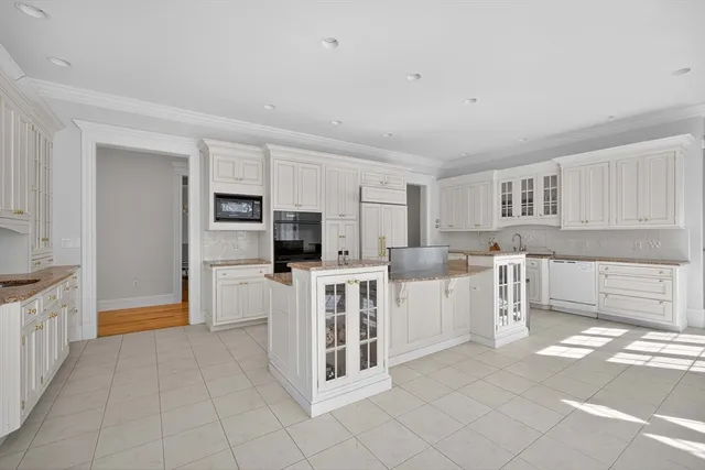 a large white open kitchen with cabinets and chairs