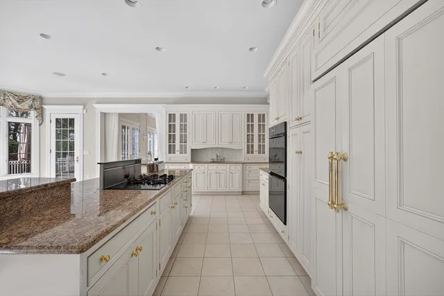 a large white kitchen with stainless steel appliances granite countertop a sink and cabinets