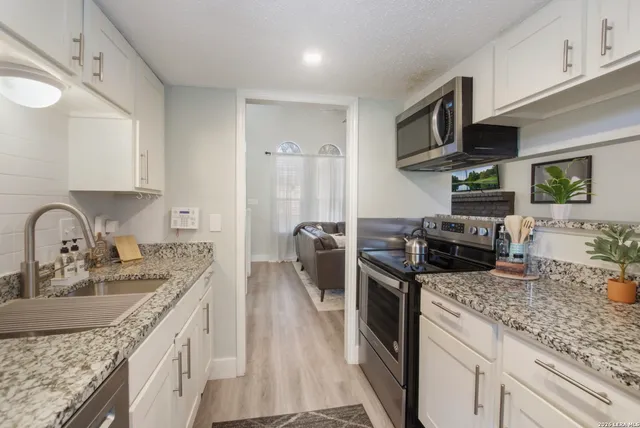 a kitchen with stainless steel appliances granite countertop a sink stove and refrigerator