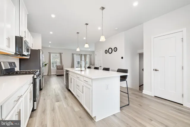 a large white kitchen with stainless steel appliances
