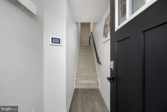 a view of a hallway with wooden floor and staircase