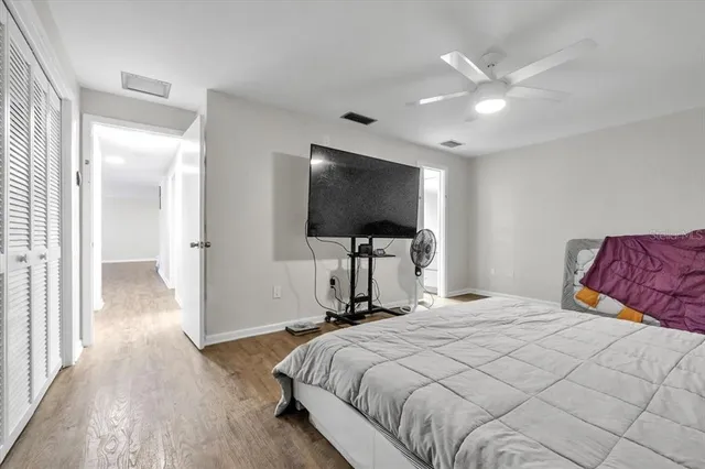 a bedroom with a bed and a flat tv screen on the dresser
