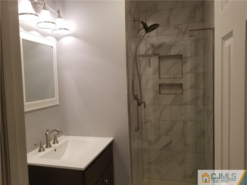 47 Harmon Road Edison, NJ 08837 - Photo 14 of 24 a bathroom with a sink a mirror and shower