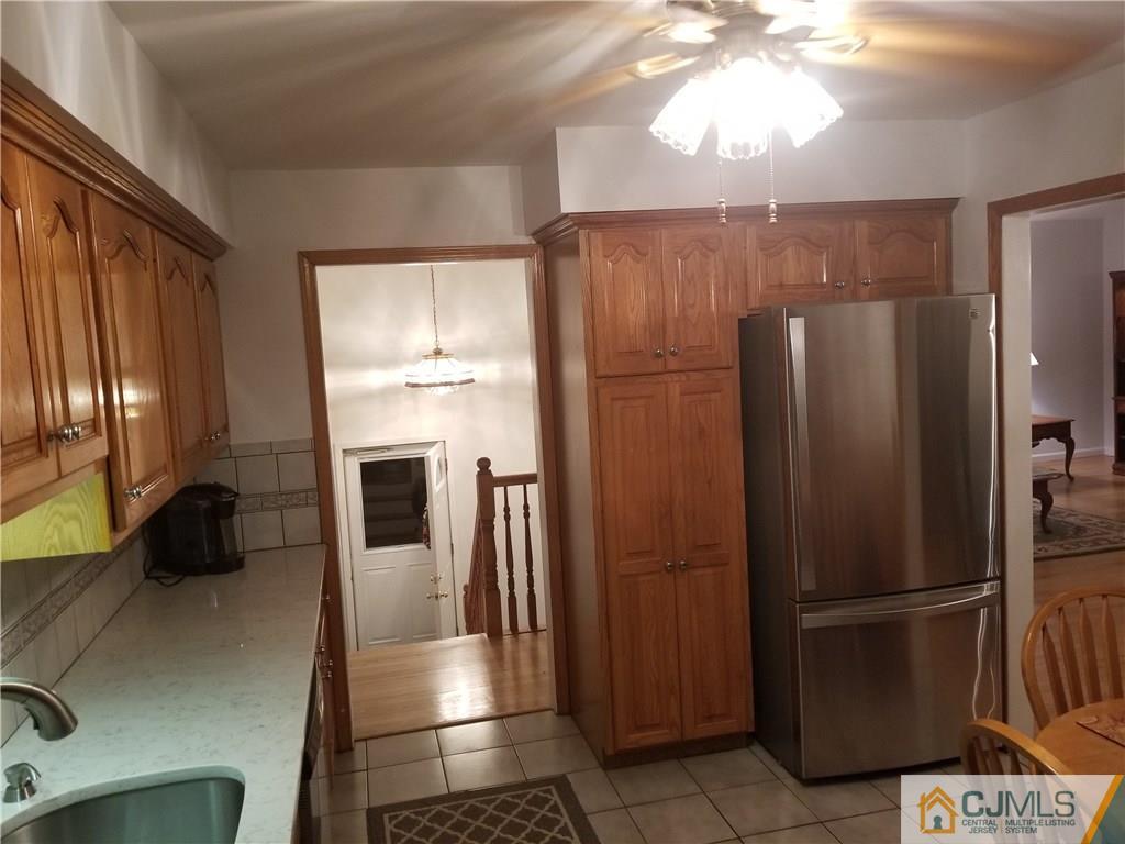 47 Harmon Road Edison, NJ 08837 - Photo 7 of 24 a kitchen with stainless steel appliances granite countertop a refrigerator a stove and a sink with wooden floor