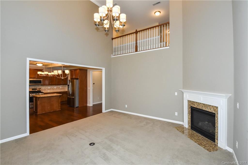 7079 Meyer Road Fort Mill, SC 29715 - Photo 10 of 20 a view of a livingroom with a fireplace a chandelier and windows