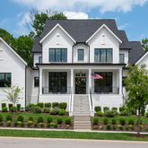 a front view of a house with a yard and trees