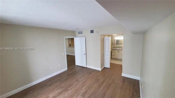 a view of empty room with wooden floor