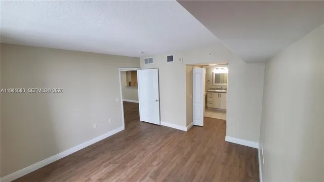 a view of empty room with wooden floor