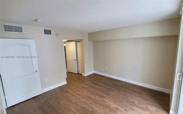an empty room with wooden floor and closet