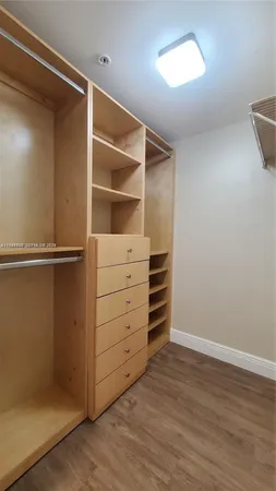 a view of walk in closet with empty racks