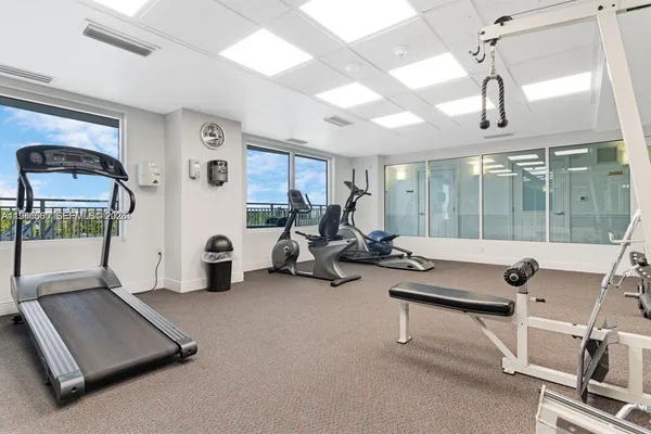 a room with gym equipment and large mirror