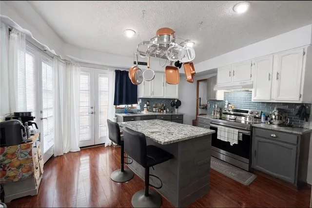 a kitchen with stainless steel appliances granite countertop a lot of counter space and wooden floor
