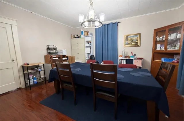 a view of a dining room with furniture a chandelier and wooden floor