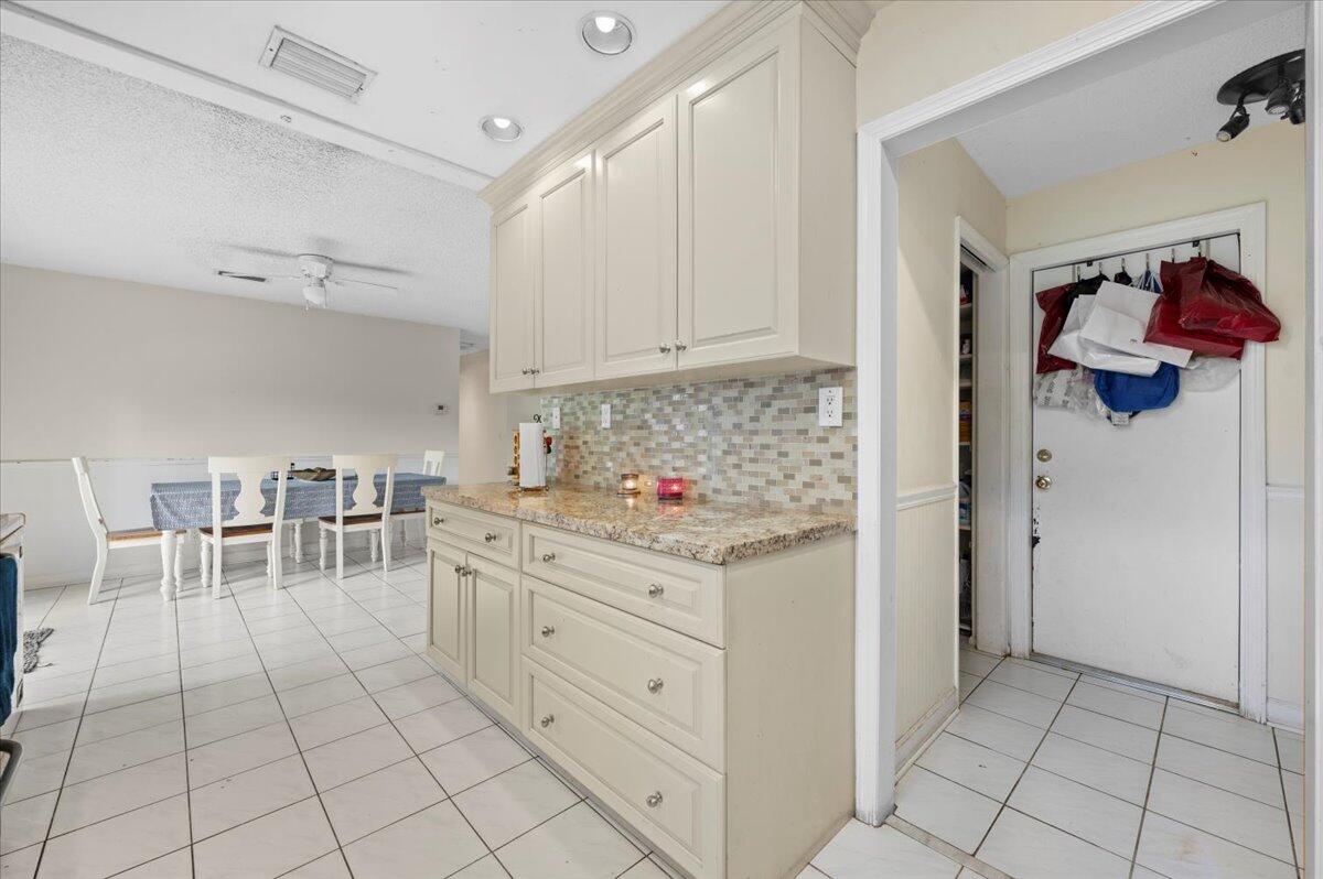 19309 Carolina Circle Boca Raton, FL 33434 - Photo 14 of 30 a kitchen with white cabinets and appliances