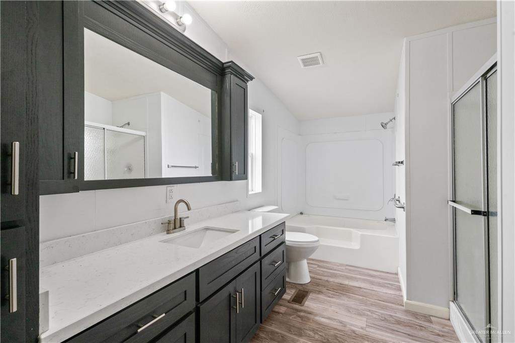 215 South Valley View Road, Unit 252 Donna, TX 78537 - Photo 10 of 19 Bathroom featuring a dark wood-finish vanity with a light countertop, integrated sink, and brushed nickel faucet