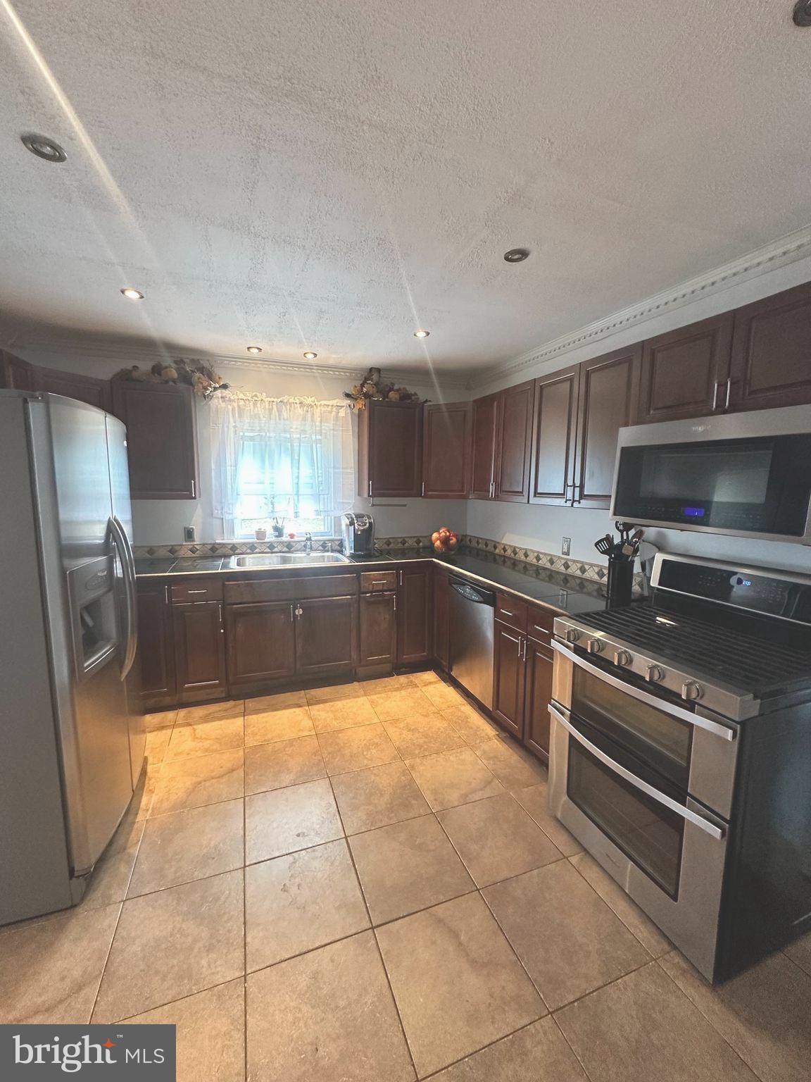 310 Pingree Avenue Ewing, NJ 08618 - Photo 11 of 28 a large kitchen with a stove a sink dishwasher and a microwave oven on the kitchen countertops