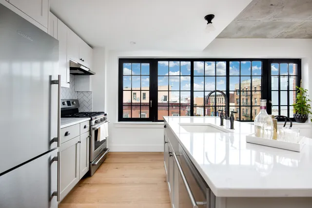 a large white kitchen with a large window