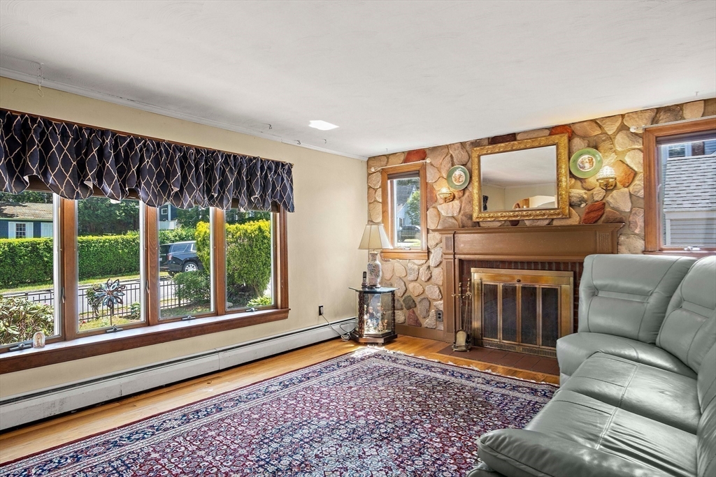 4 Merrow Lane Stoneham, MA 02180 - Photo 12 of 33 a living room with furniture a flat screen tv and a fireplace