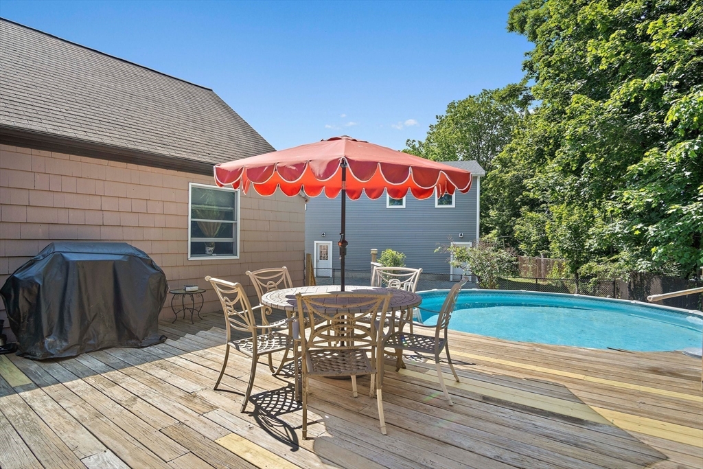 4 Merrow Lane Stoneham, MA 02180 - Photo 27 of 33 a view of a roof deck with table and chairs under an umbrella