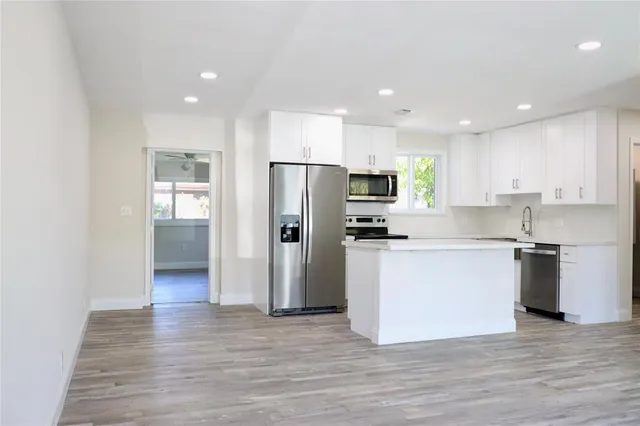 a kitchen with a refrigerator and a stove top oven