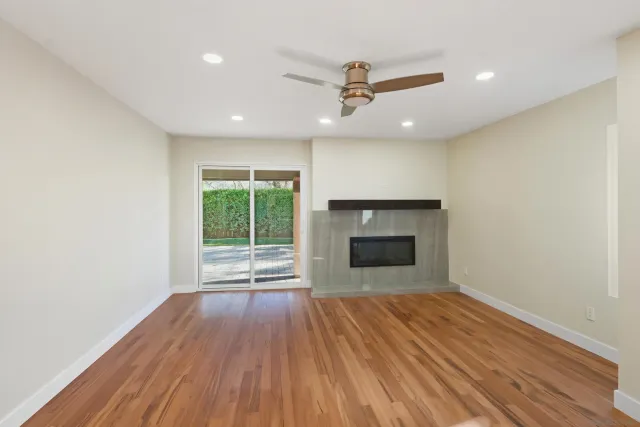 a view of empty room with wooden floor and fireplace