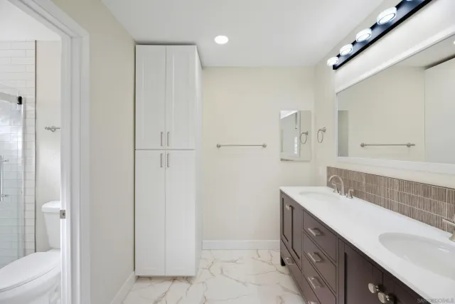a spacious bathroom with a double vanity sink a mirror and a bathtub