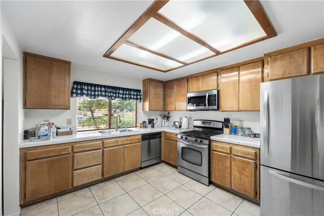 a kitchen with stainless steel appliances granite countertop a refrigerator sink and stove
