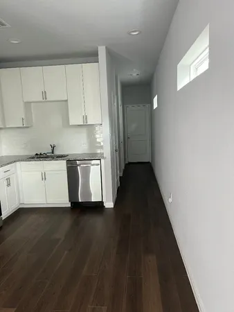 a kitchen with stainless steel appliances a sink cabinets and wooden floor