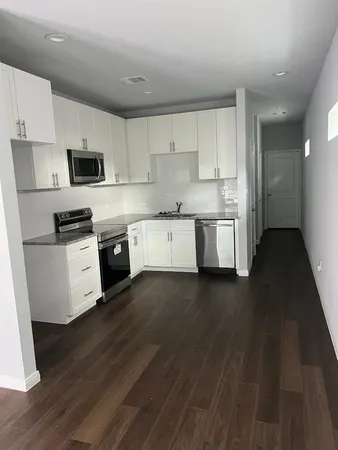 a kitchen with granite countertop a stove top oven a sink a counter space and cabinets