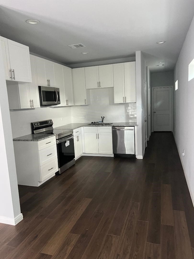 18819 Luminescent Ln Spring Spring, TX 77379 - Photo 2 of 15 a kitchen with granite countertop a stove top oven a sink a counter space and cabinets