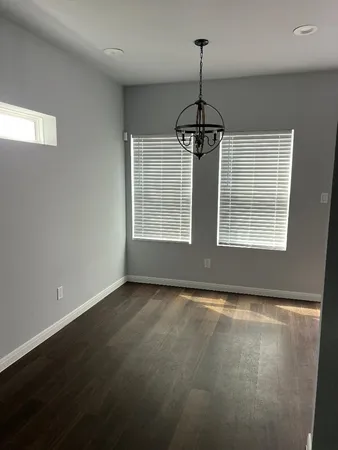 an empty room with windows and ceiling fan