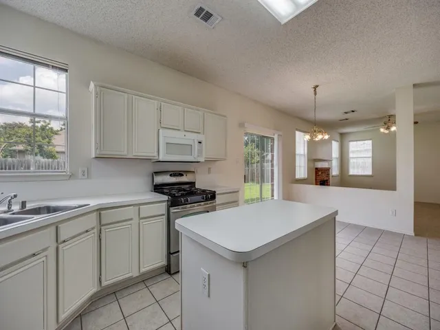 a kitchen with a sink cabinets and window