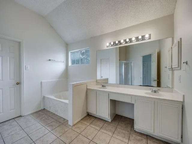 a spacious bathroom with a double vanity sink and a mirror